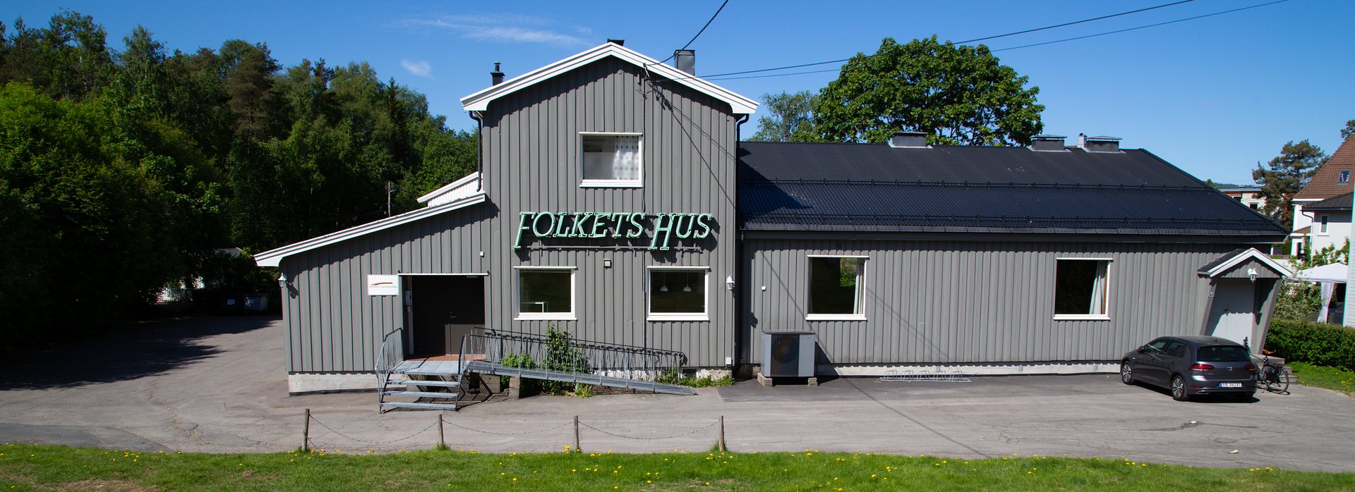 Kjelsås Folkets Hus sett fra plenen, med skiltet «Folkets Hus» på veggen.