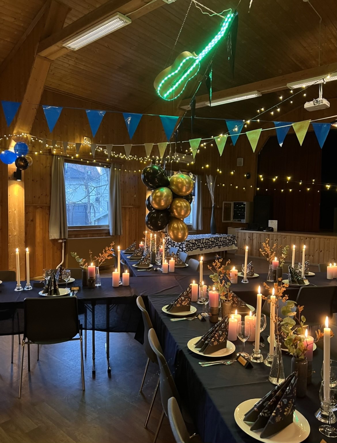 Salen pyntet til fest, med ballonger, levende lys og vimpler.